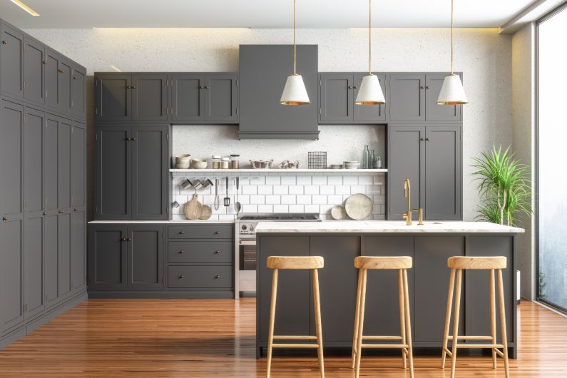 A newly renovated modern kitchen with gray tile and updated lighting.