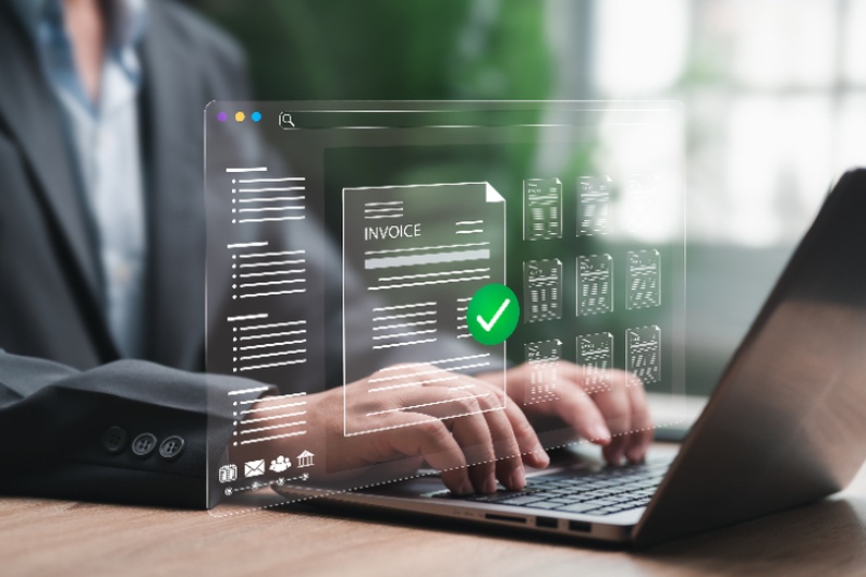 Business professional using AR automation software to process digital invoices and faster payments on a laptop.