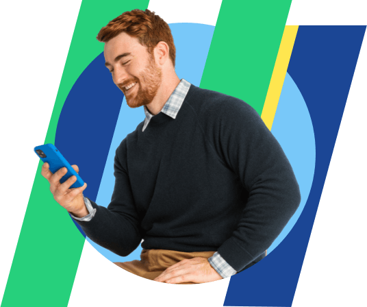 a red haired man smiles at a phone