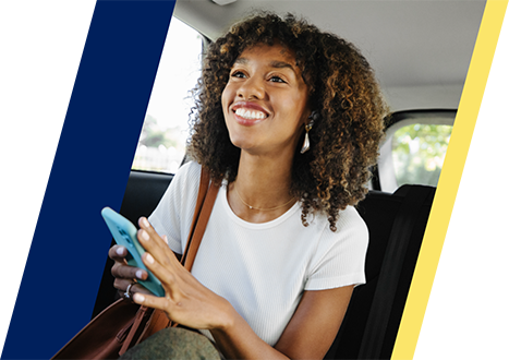 a woman in a car smiles as she holds a phone