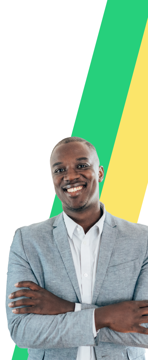 a man in a grey blazer stands with his arms crossed and smiling